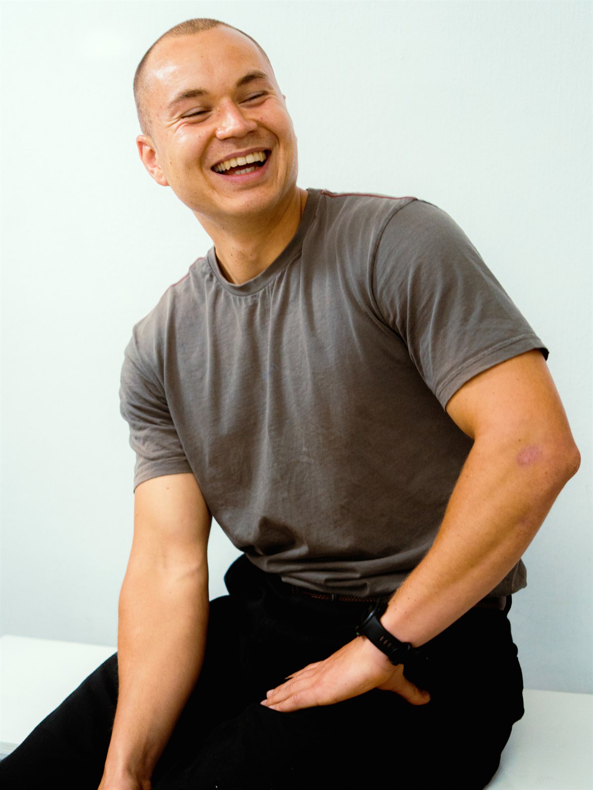 Ben Hermans, health coach, lachend in een grijs T-shirt